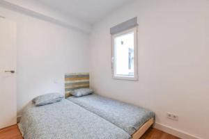 1 Schlafzimmer mit 2 Betten und einem Fenster in der Unterkunft MyHouseSpain - Moderno piso en Embajadores in Madrid