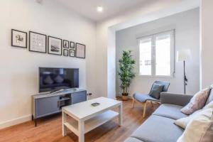 ein Wohnzimmer mit einem Sofa und einem Tisch in der Unterkunft MyHouseSpain - Moderno piso en Embajadores in Madrid