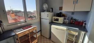 a small kitchen with a refrigerator and a microwave at LE PETIT CITRON in Menton