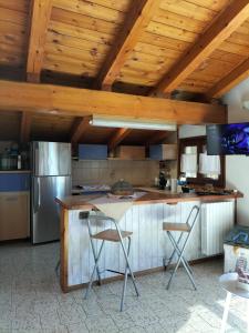 cocina con encimera y 2 taburetes en Mon grenier, en Aosta