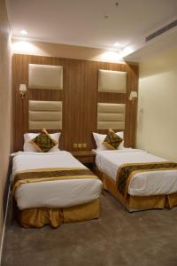 um quarto de hotel com duas camas num quarto em فندق اللؤلؤة الذهبي em Sīdī Ḩamzah