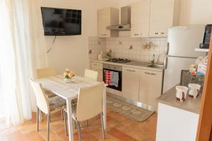 a kitchen with a table with chairs and a refrigerator at Appartamento indipendente in villa in Sanremo