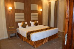 um quarto com uma cama grande num quarto em فندق اللؤلؤة الذهبي em Sīdī Ḩamzah