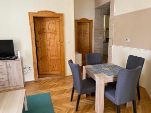 a dining room with a table and chairs and a door at Ambrózia Apartman in Eger