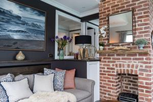 ein Wohnzimmer mit einer Couch und einem gemauerten Kamin in der Unterkunft Marners Rock No 2 in Fowey