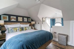 ein Schlafzimmer mit einem großen Bett mit blauer Bettwäsche in der Unterkunft Marners Rock No 2 in Fowey
