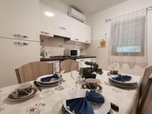 a kitchen with a table with chairs and a dining room at Apartman Krčina in Krnica