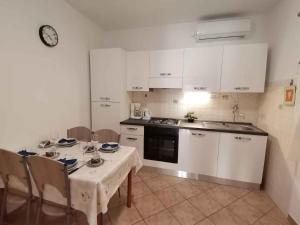 a kitchen with a table and a white table and chairs at Apartman Krčina in Krnica