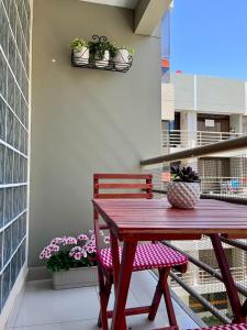 una mesa de madera y un banco en un balcón con macetas en Hermoso Departamento dentro de un Condominio, en Chiclayo