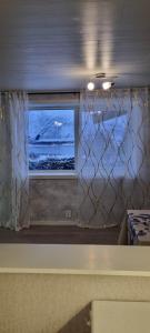 una ventana en una habitación con vistas al océano en Holiday apartment, en Kleppstad
