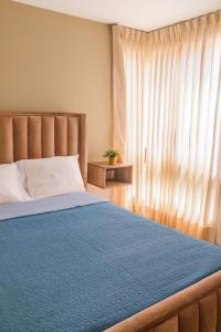 a bedroom with a blue bed with a window at Hermoso Departamento dentro de un Condominio in Chiclayo