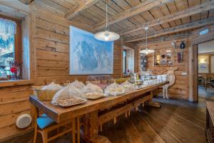 una gran mesa de madera en una habitación con paredes de madera en Valbruna Inn Bed & Breakfast en Valbruna