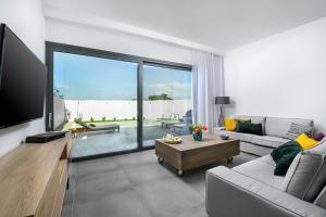 a living room with a couch and a tv at 5star Villa Harmony w heated pool, Gym, Spa, Sauna in Skalánion