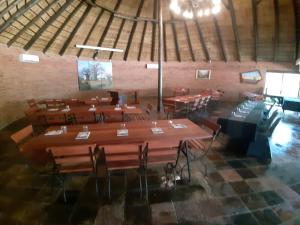 Habitación grande con mesas y sillas. en Tapologo Lodge, en Zeerust