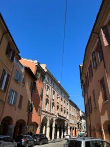 una strada cittadina con auto parcheggiate davanti agli edifici di Quiet Room a Bologna