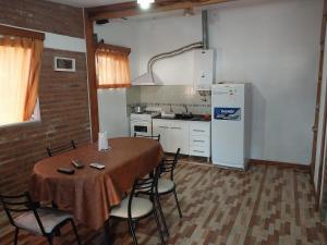 y cocina con mesa, sillas y nevera. en Dpto 2. Lopez, de Ariel Reynoso en Mina Clavero