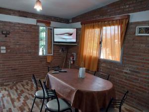 Habitación con mesa con sillas y TV. en Dpto 2. Lopez, de Ariel Reynoso en Mina Clavero