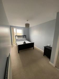 ein weißes Schlafzimmer mit einem Bett und einem Fenster in der Unterkunft Fabulous 3 Bedroom Flat in Edinburgh