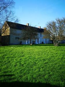 a large white house in a field of green grass at LEBAS-LADIN in Lison