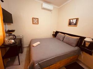 a small bedroom with a bed and a nightstand at Abrama Bed And Breakfast in Francistown
