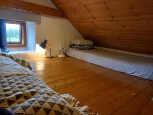 a bedroom with a bed and a wooden floor at Druid cottage in Glendree