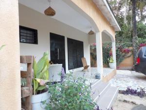 a porch of a house with flowers and plants at POMBO KUNDA in Sanyang