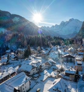 a village covered in snow with mountains in the background at Valbruna Inn Bed & Breakfast in Valbruna