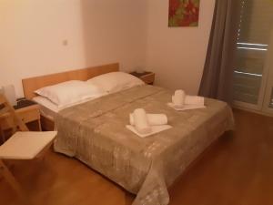 ein Schlafzimmer mit einem Bett mit zwei Handtüchern darauf in der Unterkunft Villa Zvonko in Makarska + 1 Foto