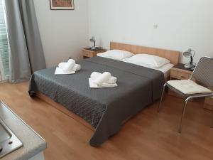 ein Schlafzimmer mit einem Bett mit zwei weißen Handtüchern darauf in der Unterkunft Villa Zvonko in Makarska