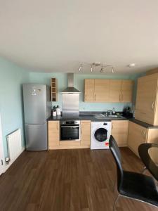 a kitchen with a refrigerator and a stove top oven at Fabulous 3 Bedroom Flat in Edinburgh +2 photos