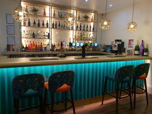 un bar avec quatre chaises et un comptoir bleu dans l'établissement Royal Sportsman Hotel, à Porthmadog