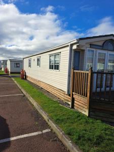 a mobile home with a porch and a fence at Windermere in Morecambe