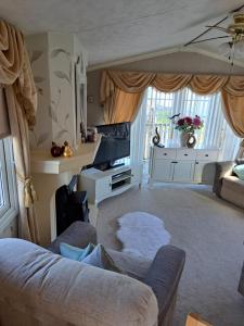 a living room with a couch and a tv at Windermere in Morecambe