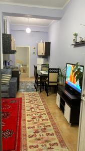 a living room with a television and a dining room at Priam Garden in Durrës