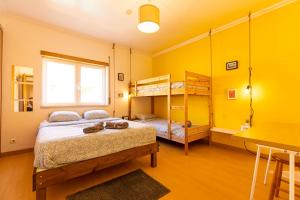 a bedroom with two bunk beds and a table at Pineapple Surf House in Peniche