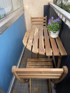 un banco de madera sentado en un balcón con una maceta en Appartement Luxembourg centre, en Luxemburgo