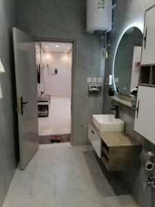 y baño con ducha, lavabo y espejo. en شقة فاخرة حي الرمال en Riad