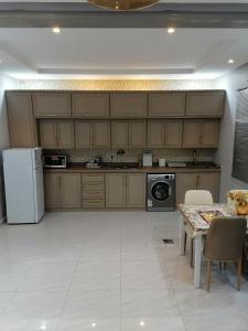 cocina con mesa y nevera blanca en شقة فاخرة حي الرمال en Riad