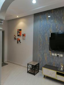 شقة فاخرة حي الرمال في الرياض: غرفة معيشة مع تلفزيون بشاشة مسطحة على جدار