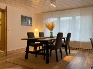 a dining room table with chairs and a vase on it at Ferienwohnung bei Bad Ems im Lahntal in Fachbach
