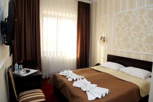 a hotel room with a bed with white flowers on it at BeSt Hotel and Restaurant complex in Dunaivtsi +74 photos