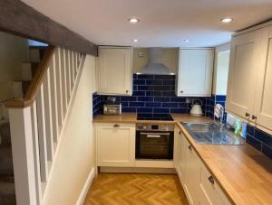 a small kitchen with a sink and a stove at Ryburn View Cottage in Luddenden Foot