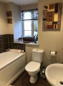 a bathroom with a white toilet and a sink at Country home near the airport in Edinburgh