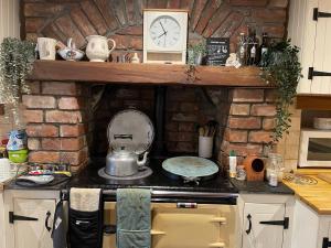 una cucina con piano cottura e parete in pietra di Country home near the airport a Edimburgo