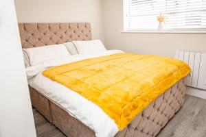 Una cama con una manta amarilla encima. en ALBERT COURT, 