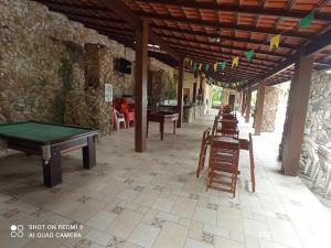 a patio with a pool table and some chairs at Maravilha de Angra in Angra dos Reis