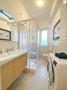 a bathroom with a sink and a washing machine at COMFORTABLE SEA HOLIDAYS AND WALKS in Moneglia