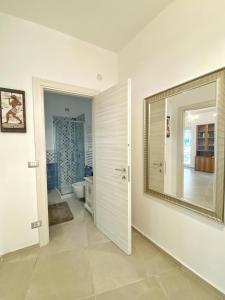 een badkamer met een toilet en een grote spiegel bij COMFORTABLE SEA HOLIDAYS AND WALKS in Moneglia