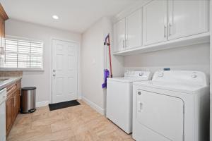 lavadero blanco con lavadora y secadora en Pristine & Exquisitely Designed APT 7 Min From TX Med Center, en Houston