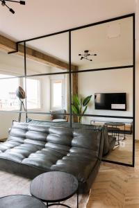 um grande sofá de couro numa sala de estar com um grande espelho em Patio de Luces em Jumilla